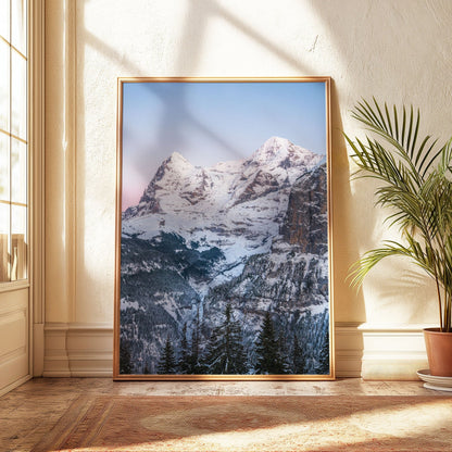 Snow-covered peaks of Eiger and Mönch with a serene forest below.