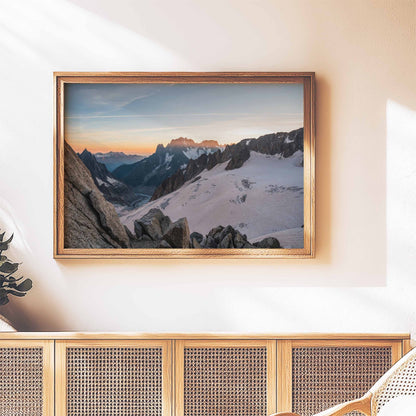 Sunset view of Mer de Glace glacier in a wooden frame, displayed on a modern console.