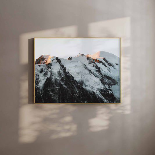 Framed wall art print of the Mont Blanc massif glowing in the warm sunset light, styled with natural shadows.