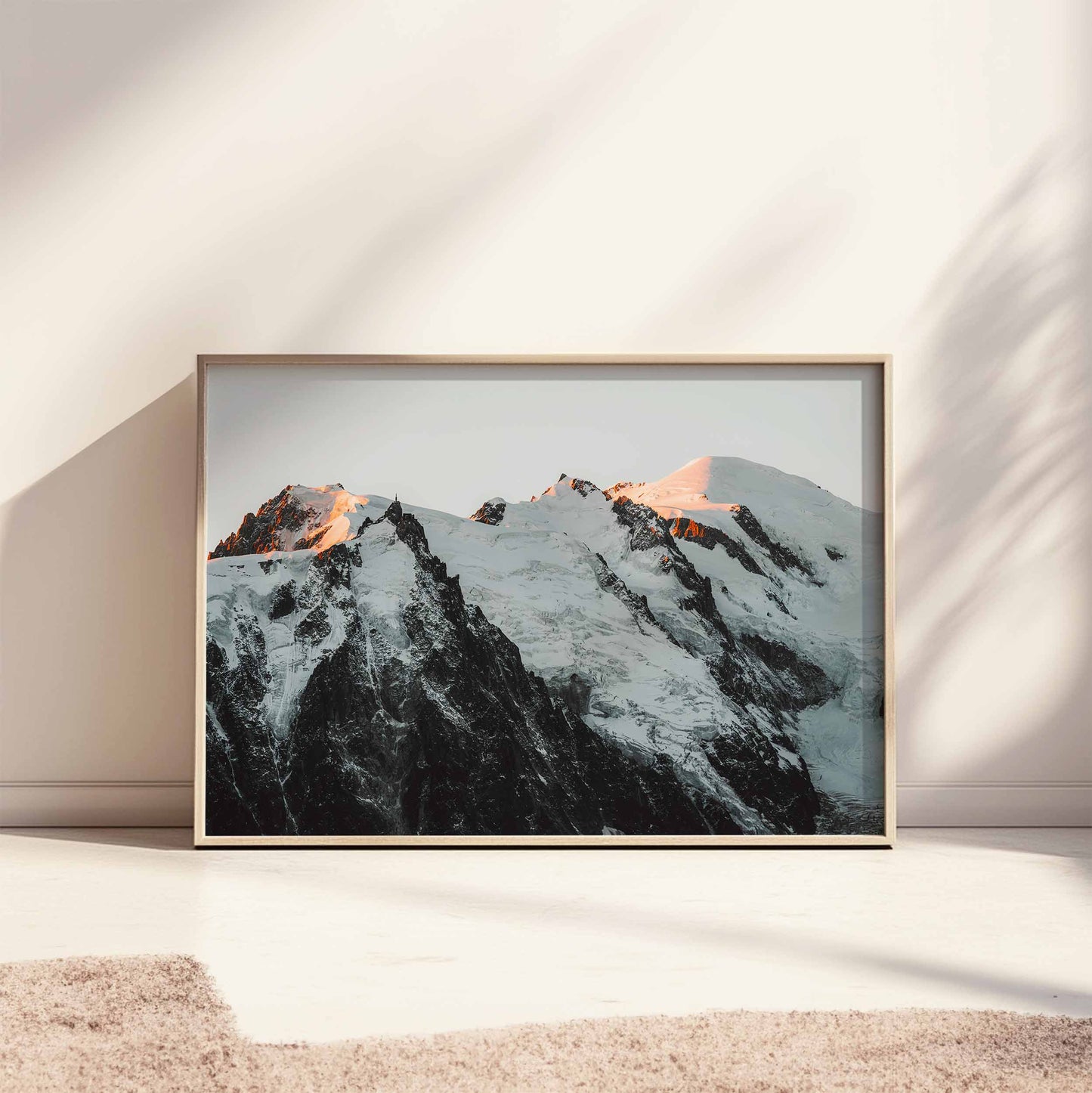 Large framed Mont Blanc massif sunset print styled on a sunlit floor for a minimalist decor look.