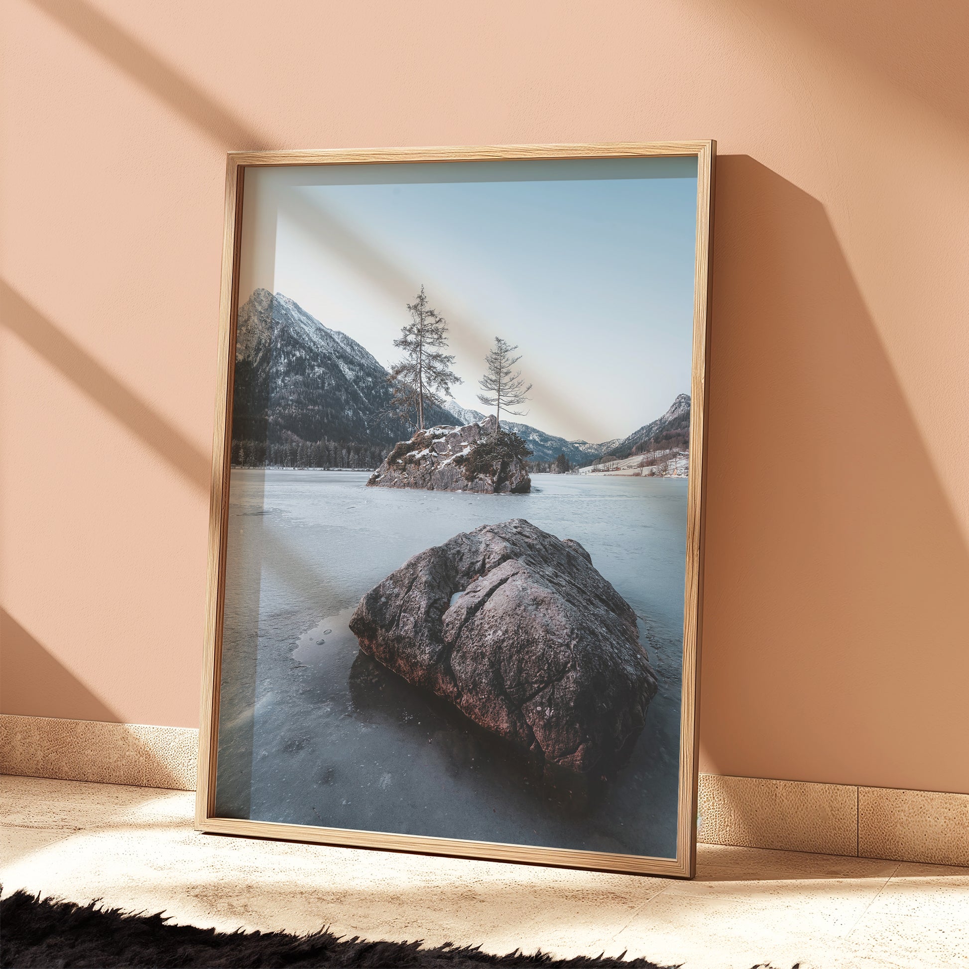 Hintersee photo print leaning against a peach wall with long winter shadows