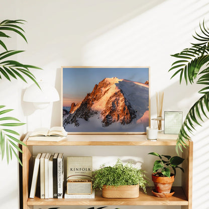 Framed Mont Blanc du Tacul photograph on a wooden shelf beside potted plants and books