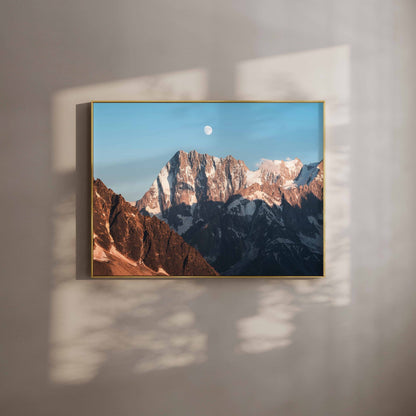 Grandes Jorasses wall art print with moon in sky, shown in a white-walled room with natural light
