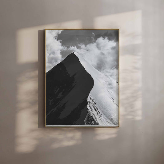 A stunning black-and-white photograph of the Aiguille de Bionnassay summit against dramatic clouds in the French Alps.