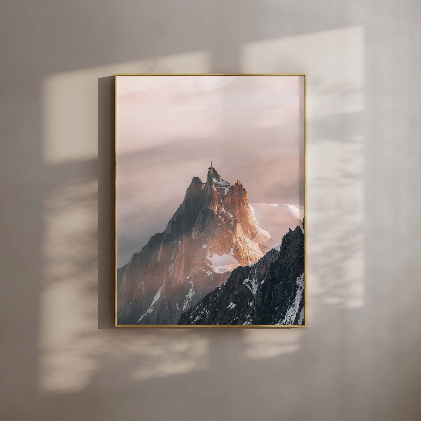 A dramatic view of Aiguille du Midi with morning light illuminating the rocky peak and surrounding glacier in Chamonix.