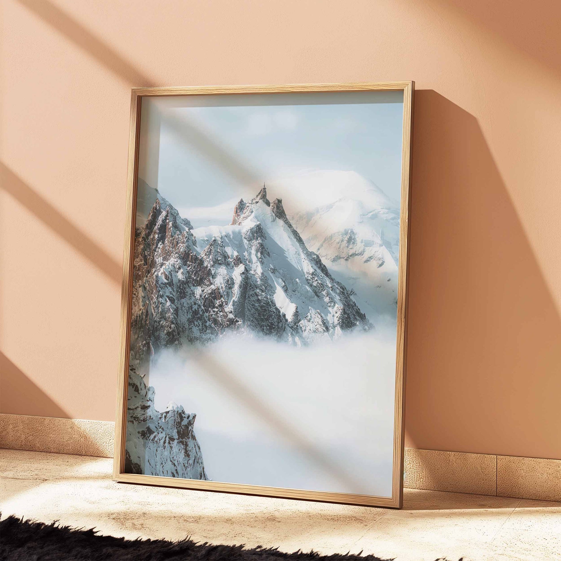 Snow-covered Aiguille du Midi mountain peak above clouds in Chamonix.