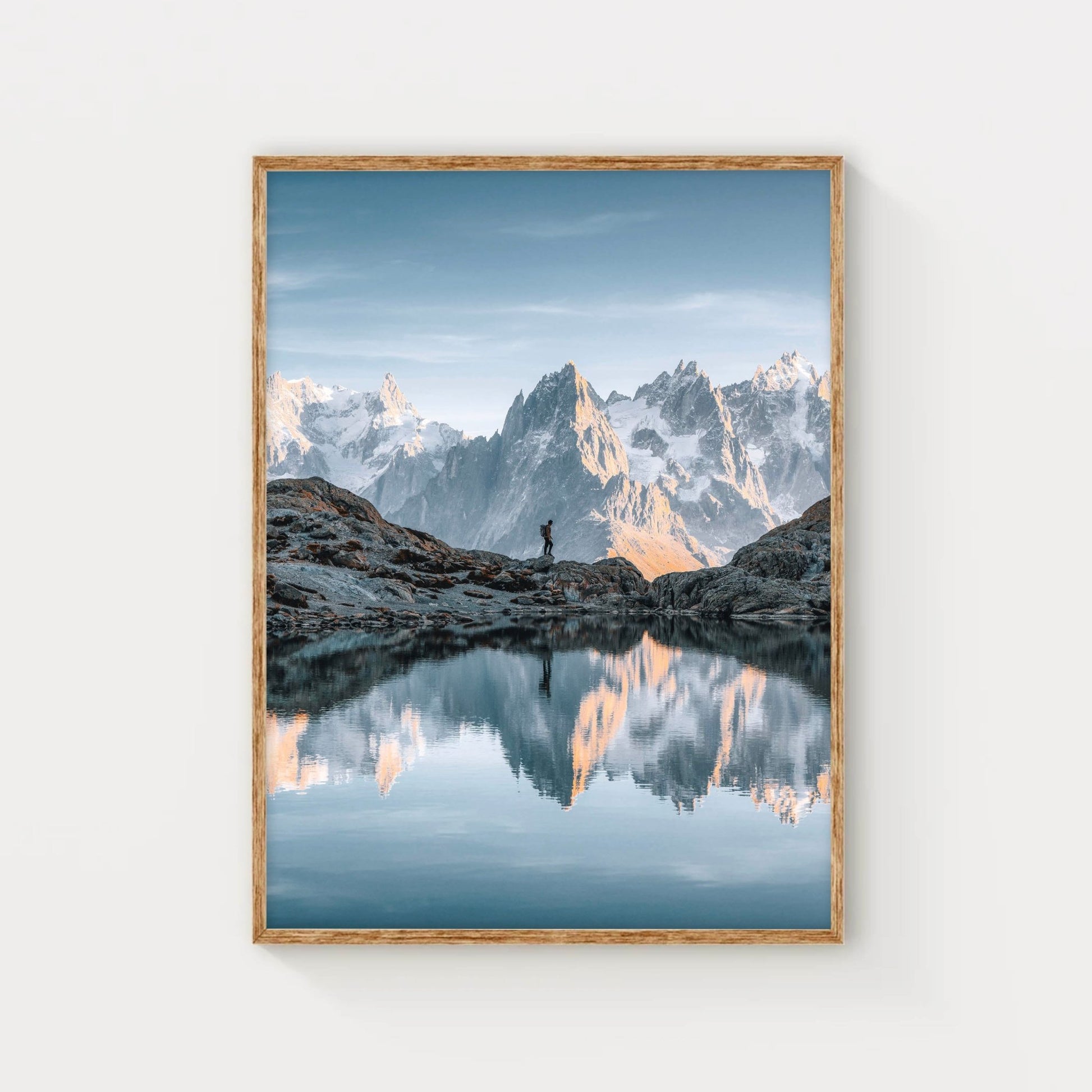 Aiguille du Midi mountain peak at sunset, surrounded by soft clouds.