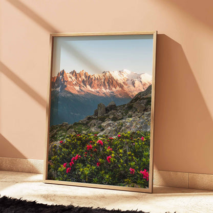 Artistic representation of Aiguilles de Chamonix with blooming pink flowers in alpenglow.