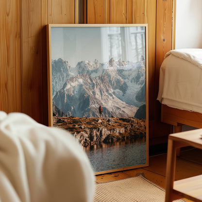 A mesmerizing alpine lake photography print with a hiker exploring the mountain trails.
