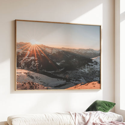 Alpine sunset casting golden rays over the snowy peaks of Verbier, Switzerland.