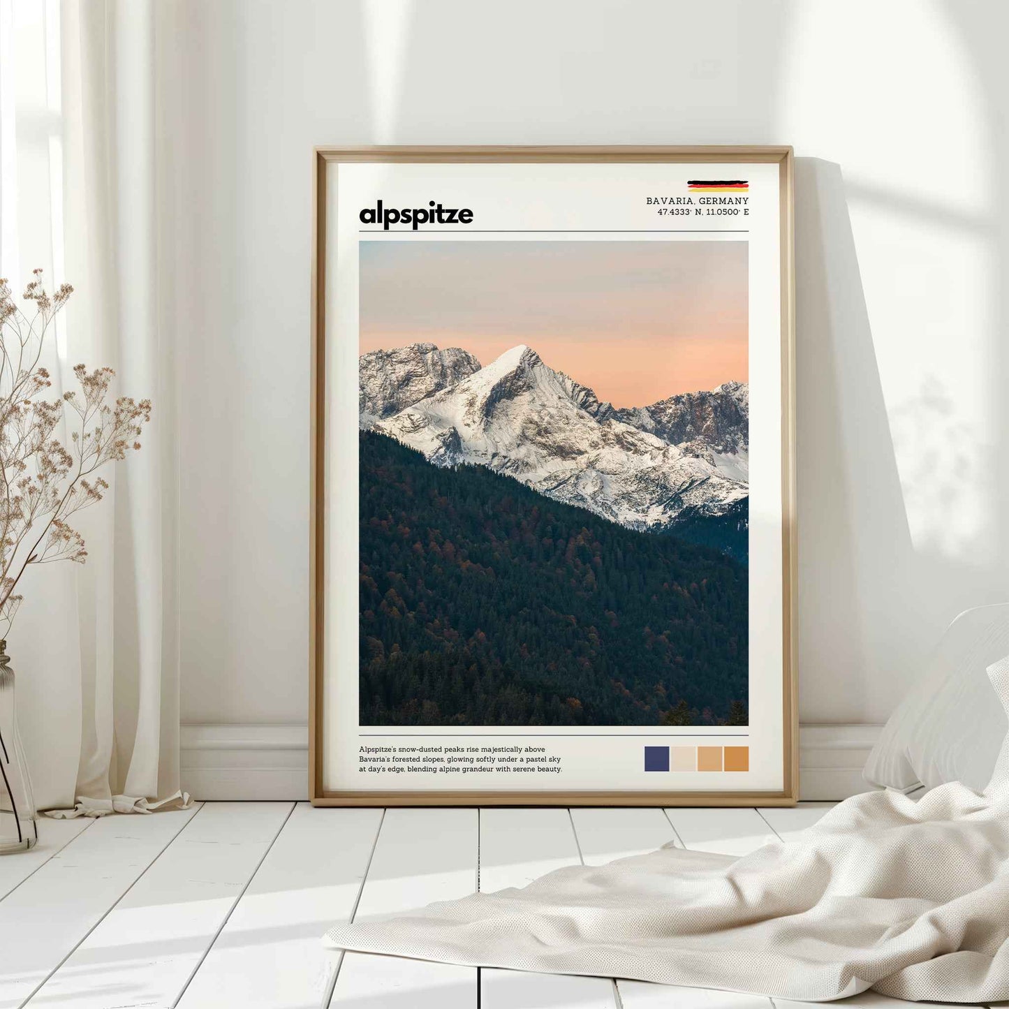 Natural wood framed Alpspitze Bavaria Germany print leaning against white wall on white floorboards in minimal Scandinavian interior