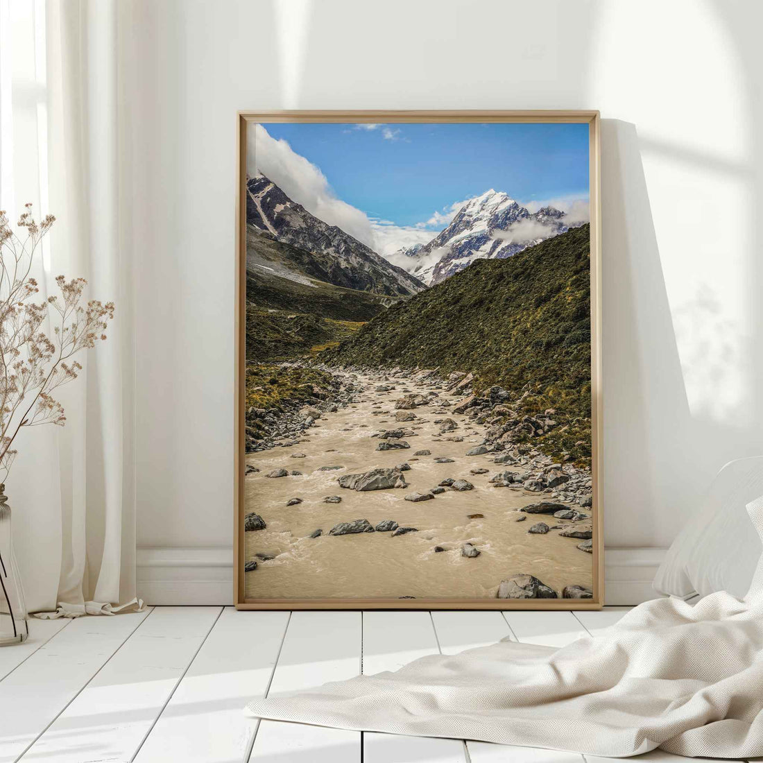Natural wood framed Aoraki Mount Cook Hooker Valley New Zealand print leaning against a white wall in a bright interior