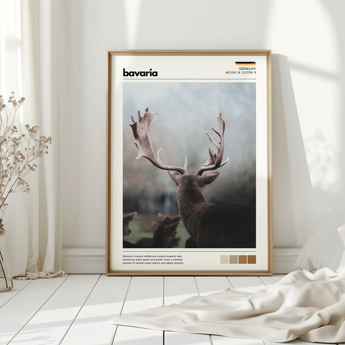 Natural wood framed Bavaria red deer stag Germany print leaning against white wall on white floorboards in minimal Scandinavian interior