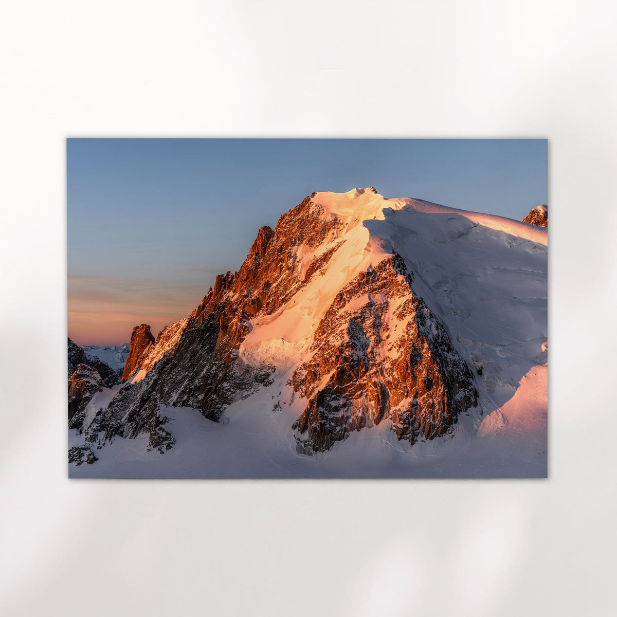 Close view of Mont Blanc du Tacul's snowy peak lit by alpenglow with a layer of cloud below