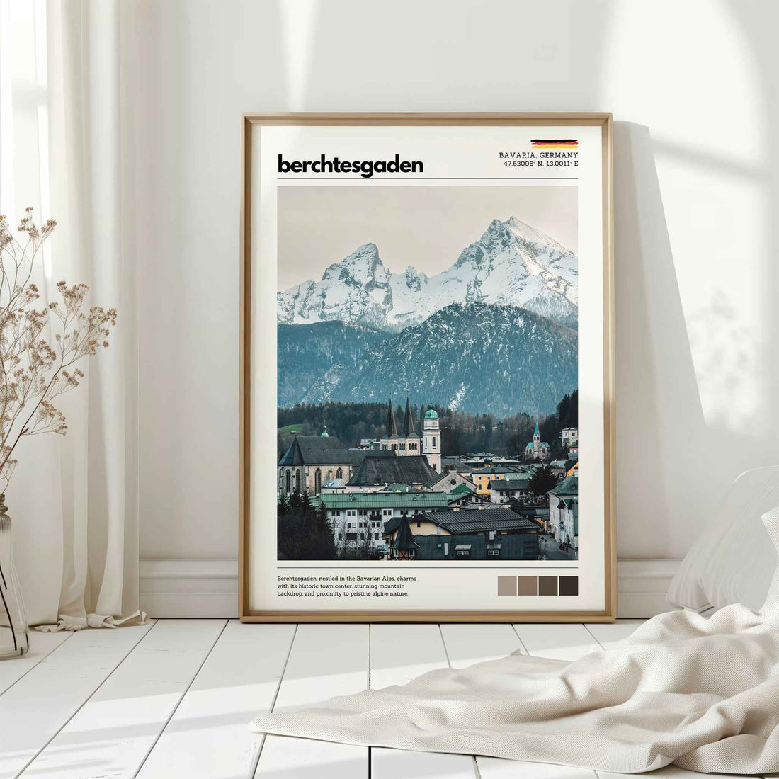 Natural wood framed Berchtesgaden Bavaria Germany town and Watzmann print leaning against white wall on white floorboards in minimal Scandinavian interior