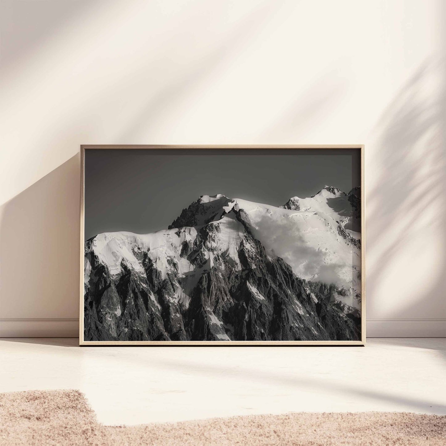 Aiguille du Midi Chamonix black and white art print leaning against a wall with natural lighting.