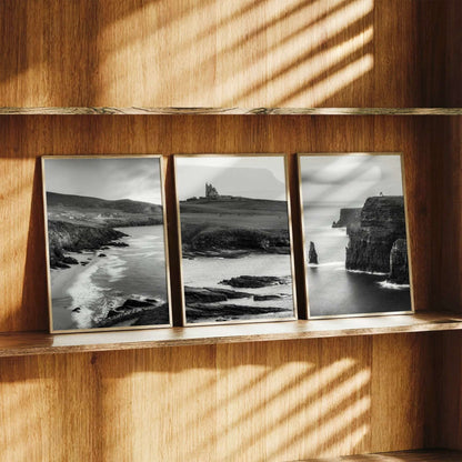 Black and white Irish coastal wall art set of three displayed on a wooden shelf with natural light