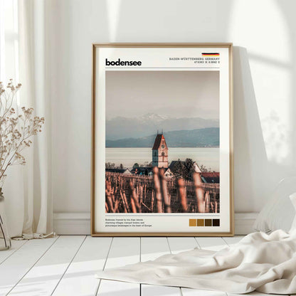 Natural wood framed Bodensee Lake Constance Germany church vineyard print leaning against white wall on white floorboards in minimal Scandinavian interior