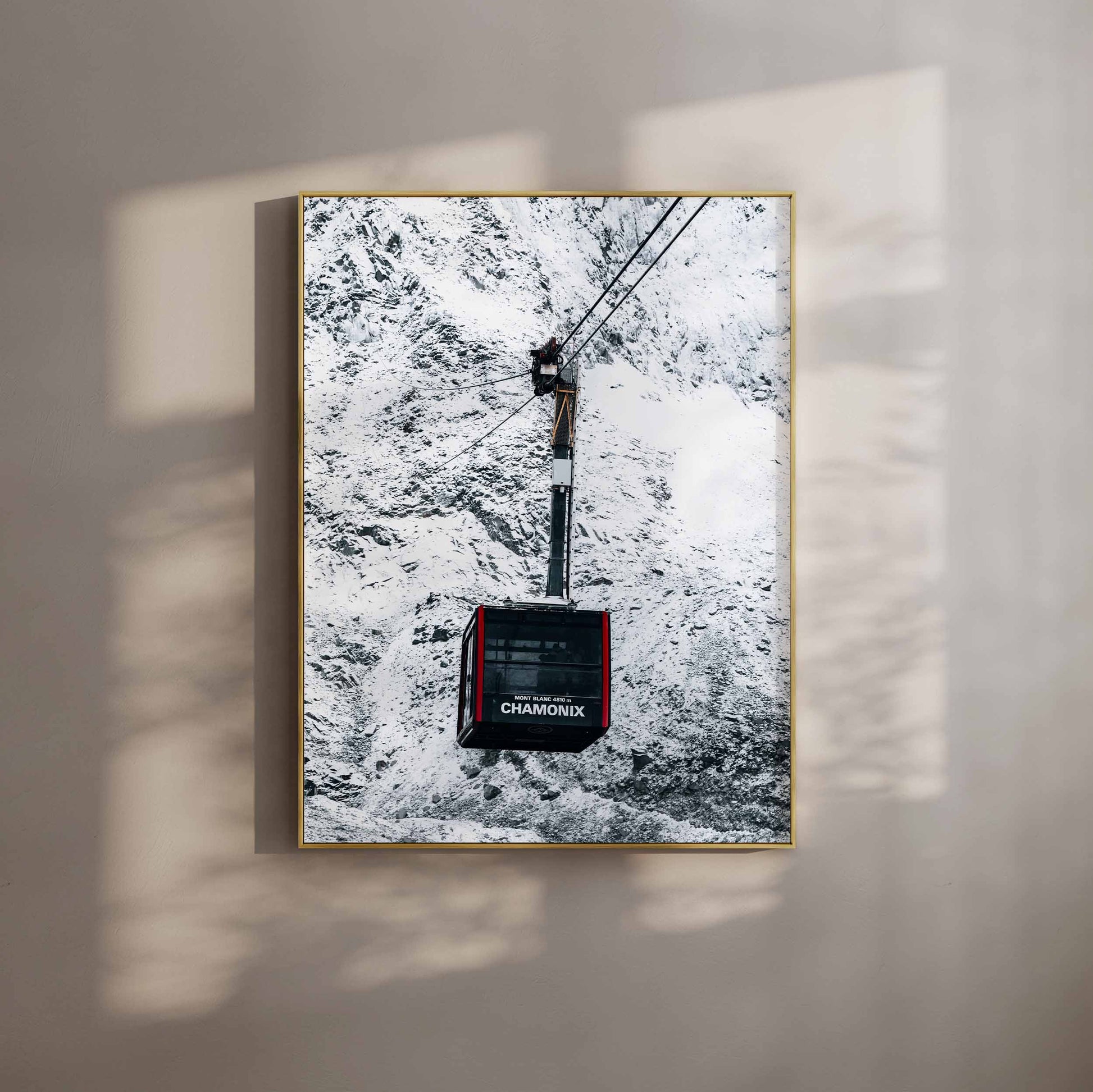 Chamonix cable car photograph displayed in a gold frame, bathed in soft, natural light.