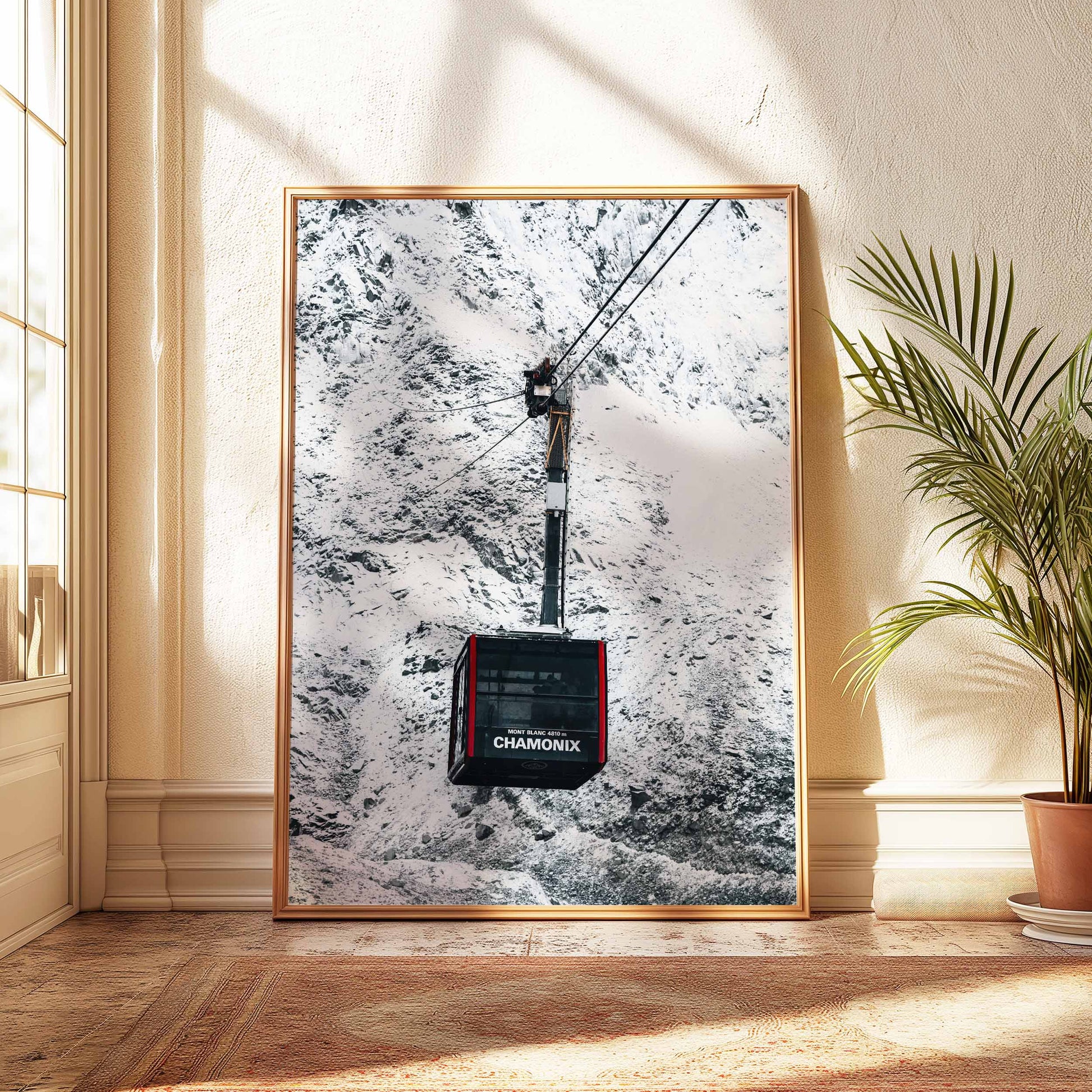 Chamonix cable car print in a natural wood frame, styled with greenery and a classic interior.