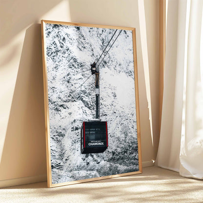 Chamonix cable car framed print leaning against a cream-colored wall with sunlight streaming in.