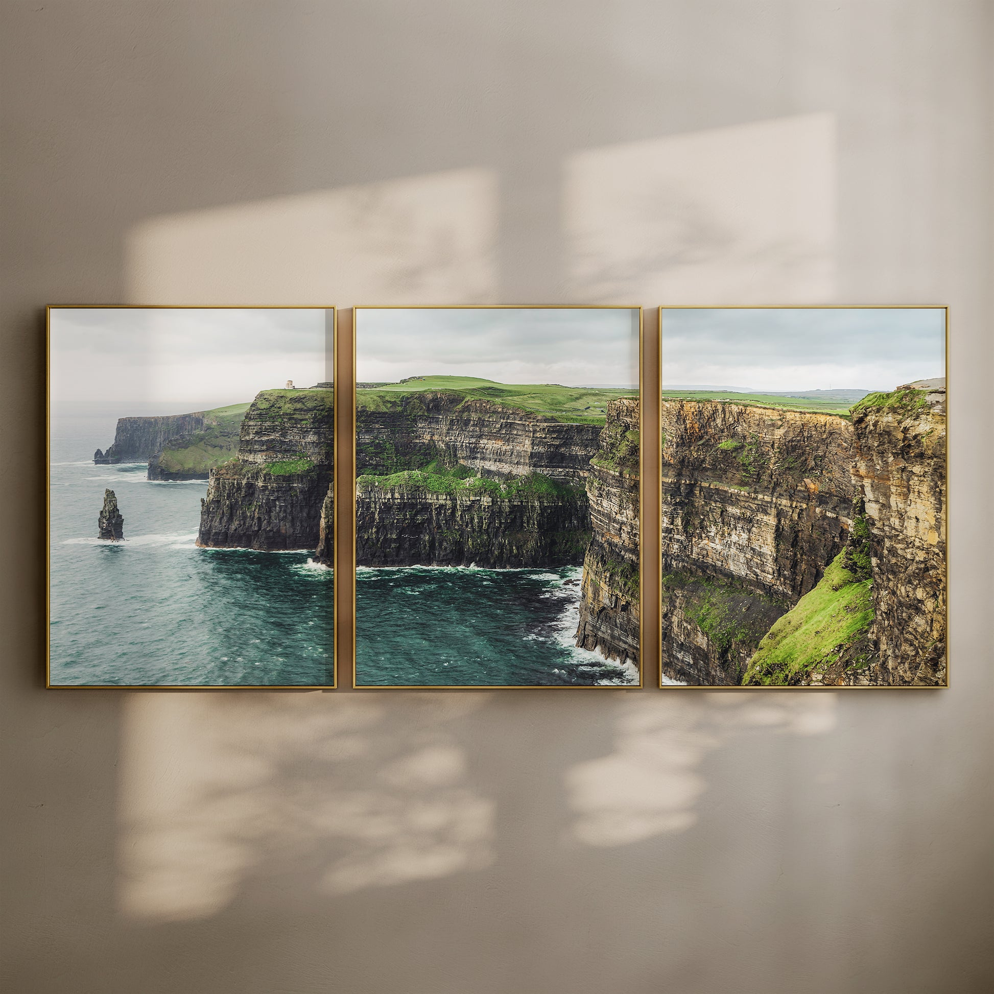 Framed triptych of the Cliffs of Moher above the sea with sunlit shadows on wall