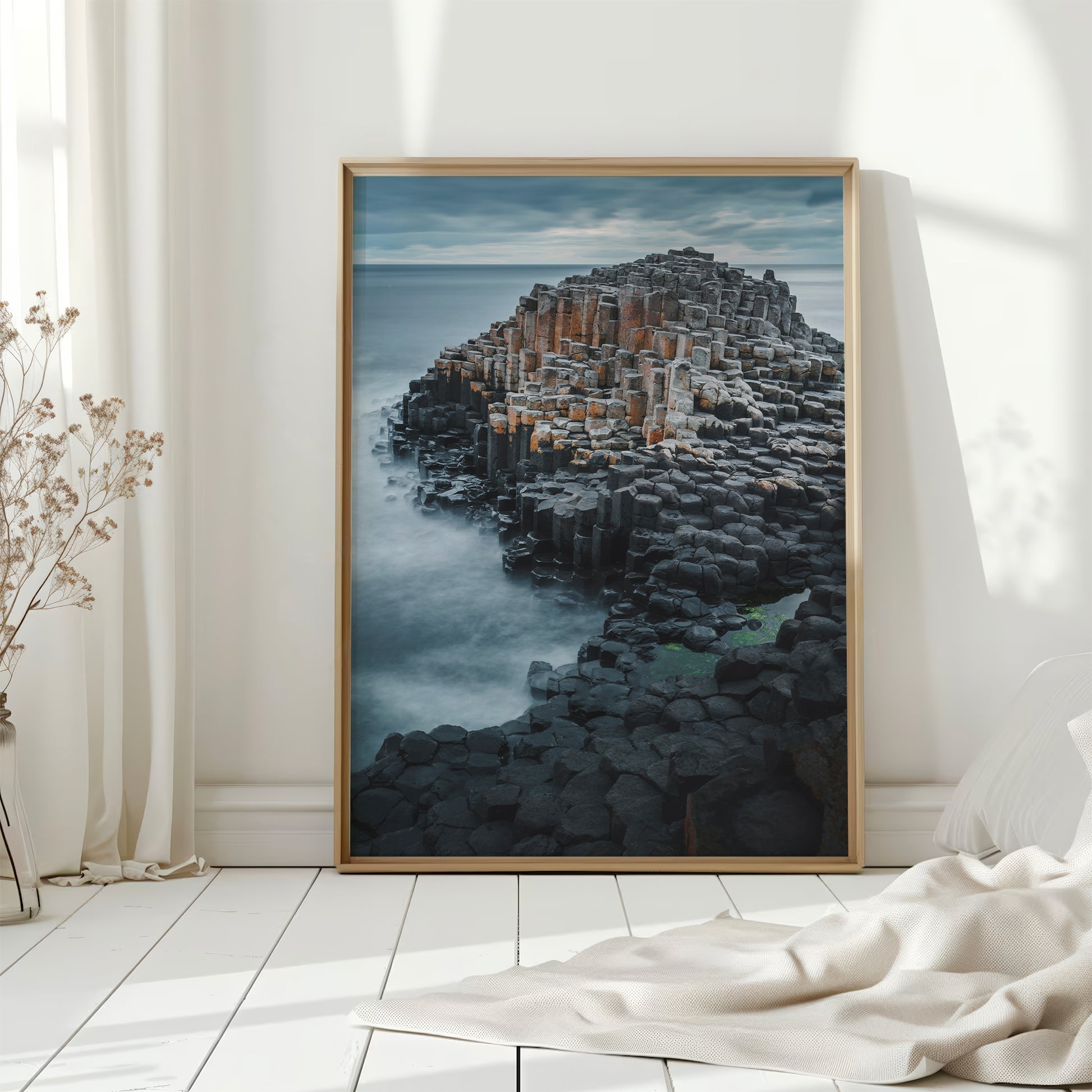 Giant's Causeway coastal wall art placed on white painted floor near curtains