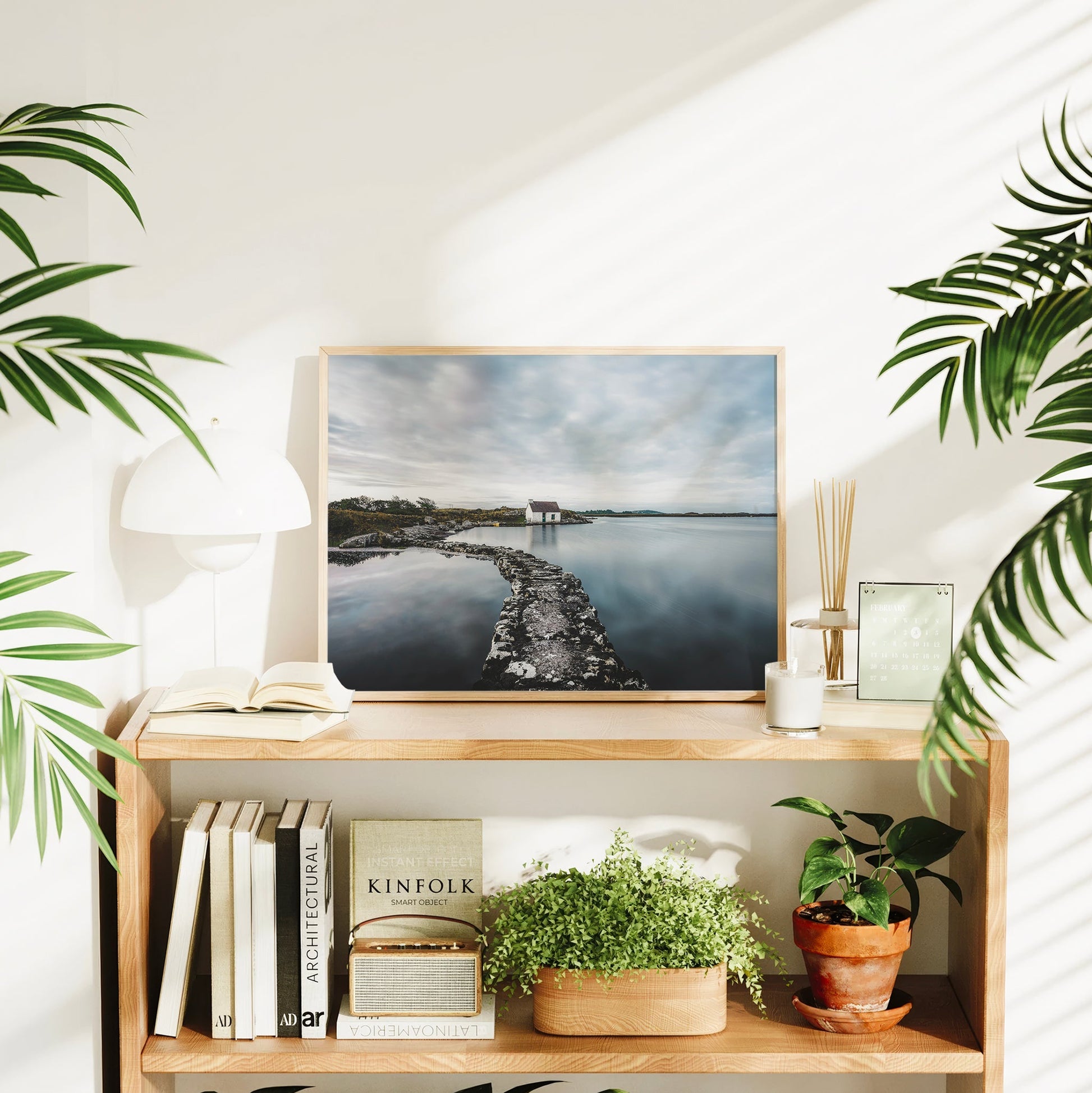 Irish landscape artwork of a coastal bothy styled in a bright modern interior.