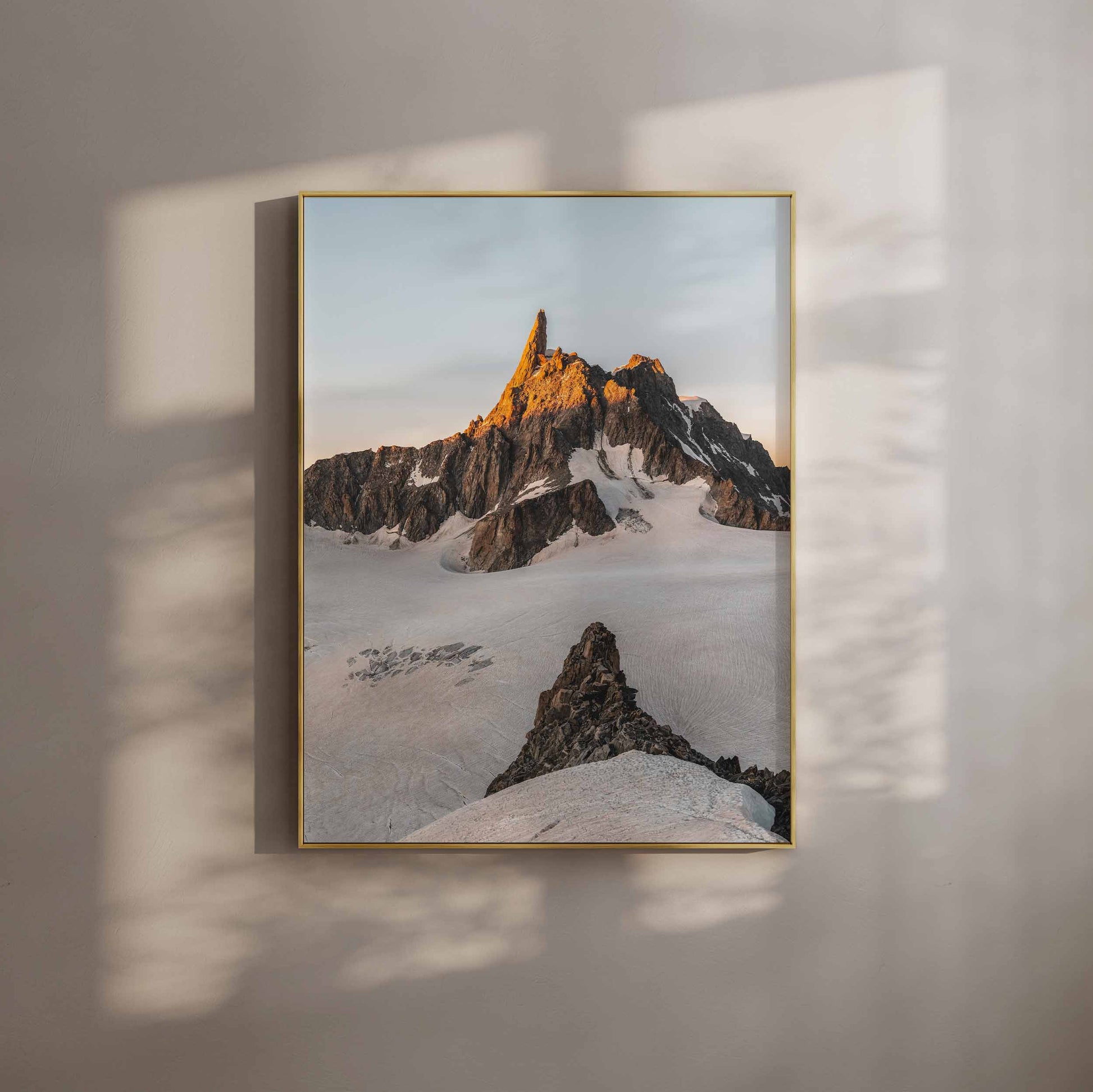 The dramatic peak of Dent de Géant glowing at sunset with a golden hue over pristine snow.