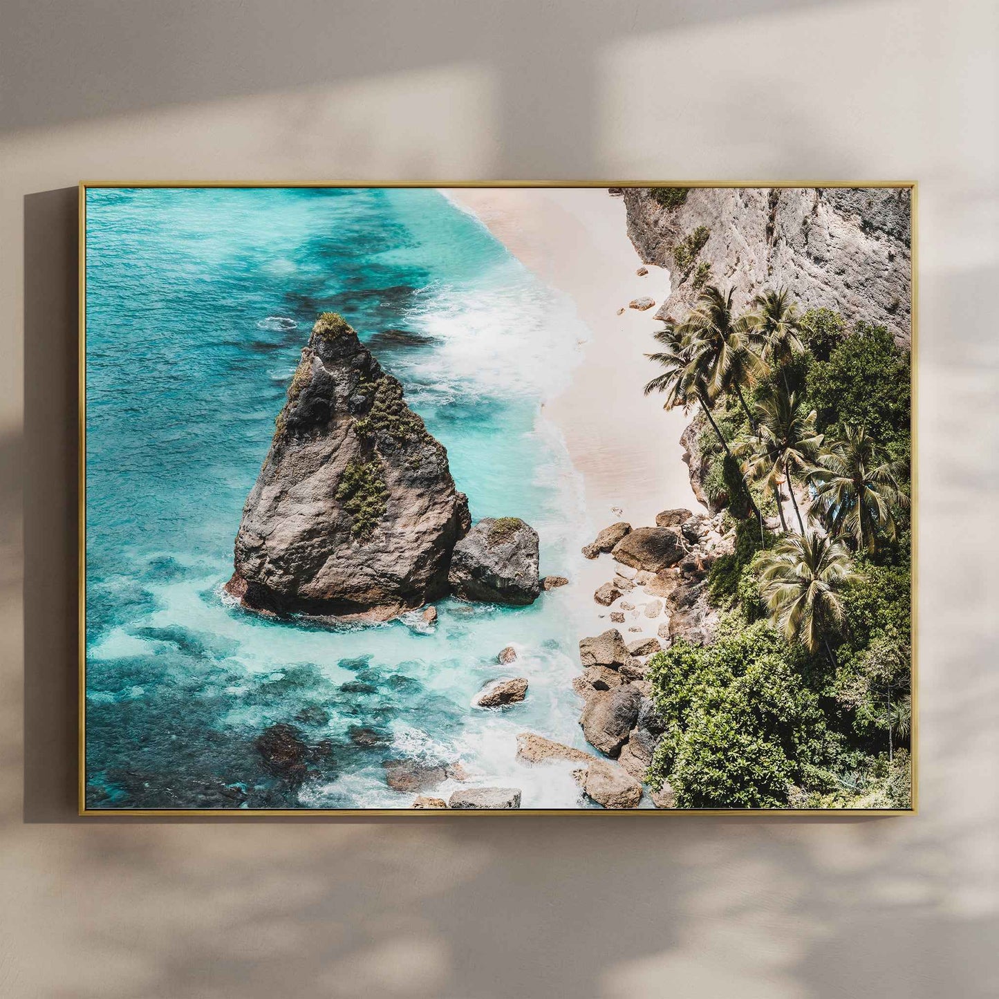 Diamond Beach Nusa Penida landscape aerial wall art print with turquoise water and rock stack in gold floating frame mounted on beige wall