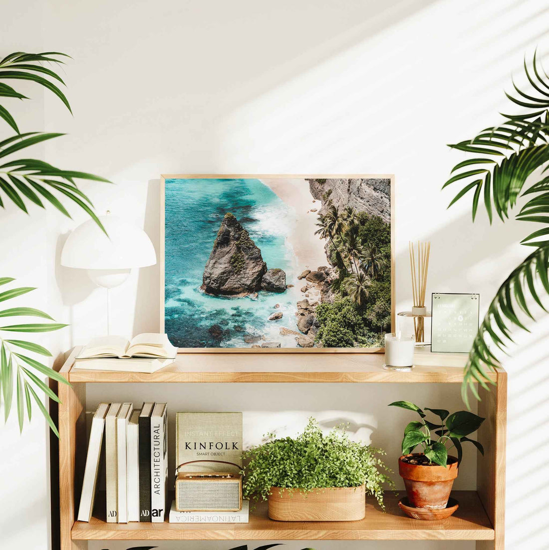 Diamond Beach Nusa Penida landscape framed wall art print in natural wood frame on bookshelf with plants and Kinfolk book
