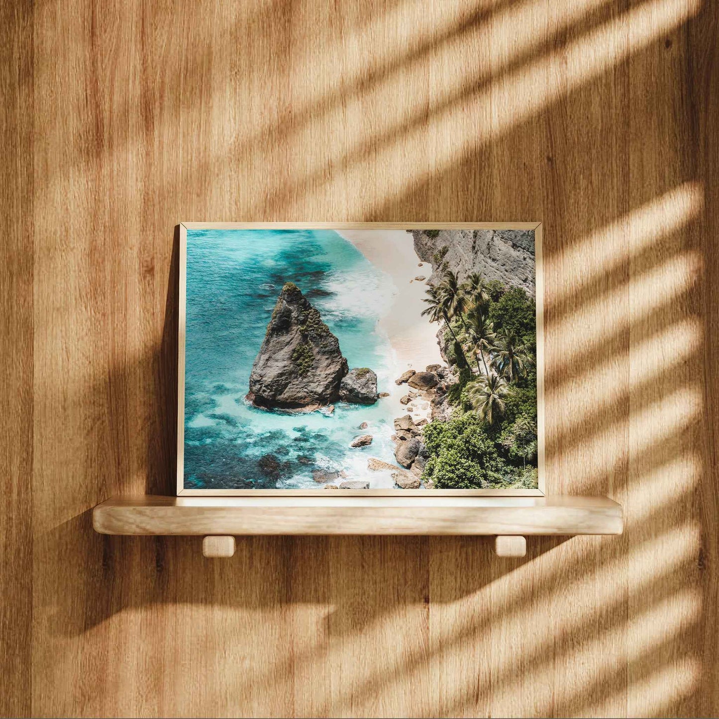 Diamond Beach Nusa Penida landscape framed photography print displayed on natural wood shelf against wooden wall with shadows