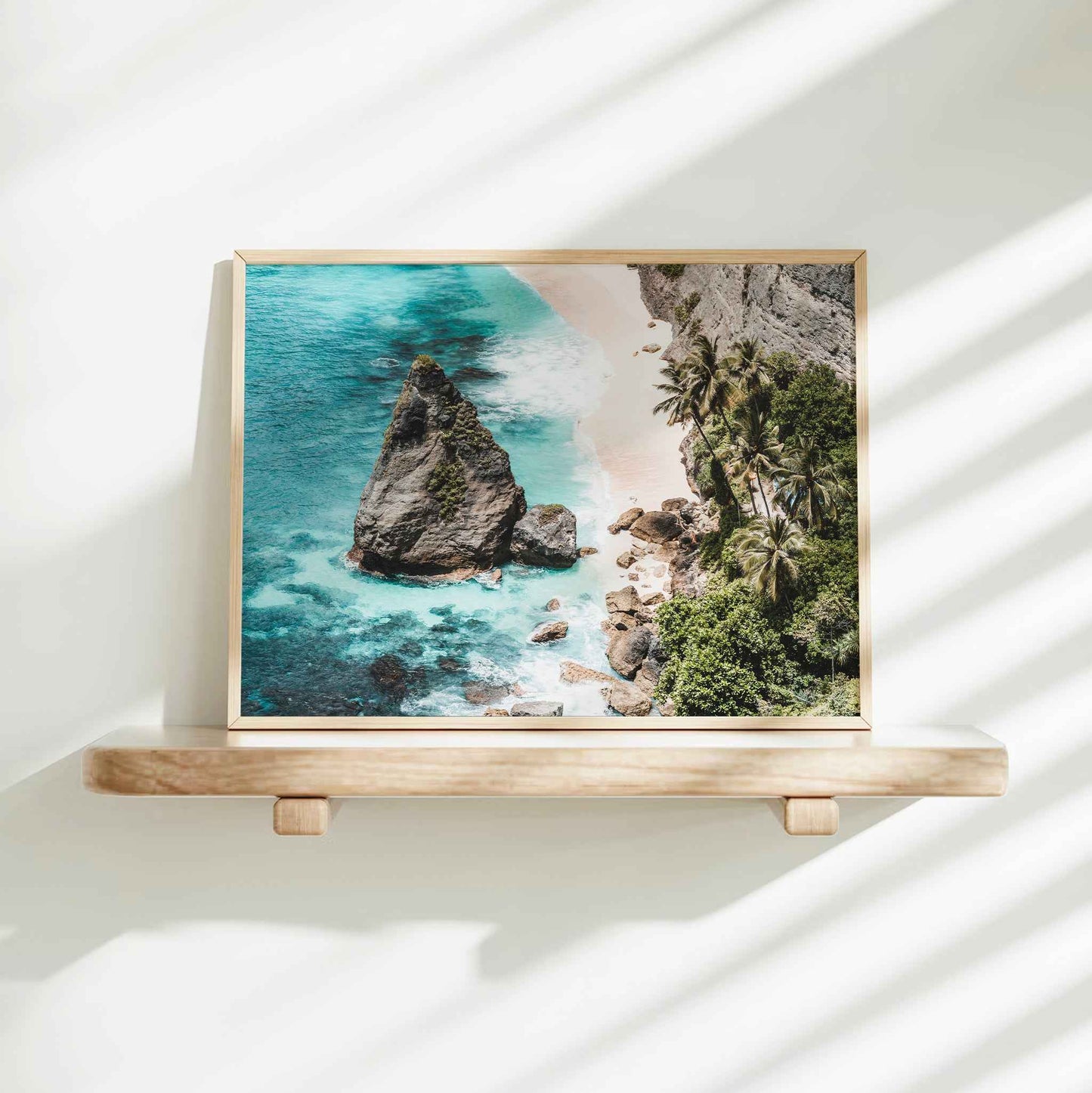Diamond Beach Nusa Penida landscape framed wall art print in natural wood frame on white wall shelf with natural shadows