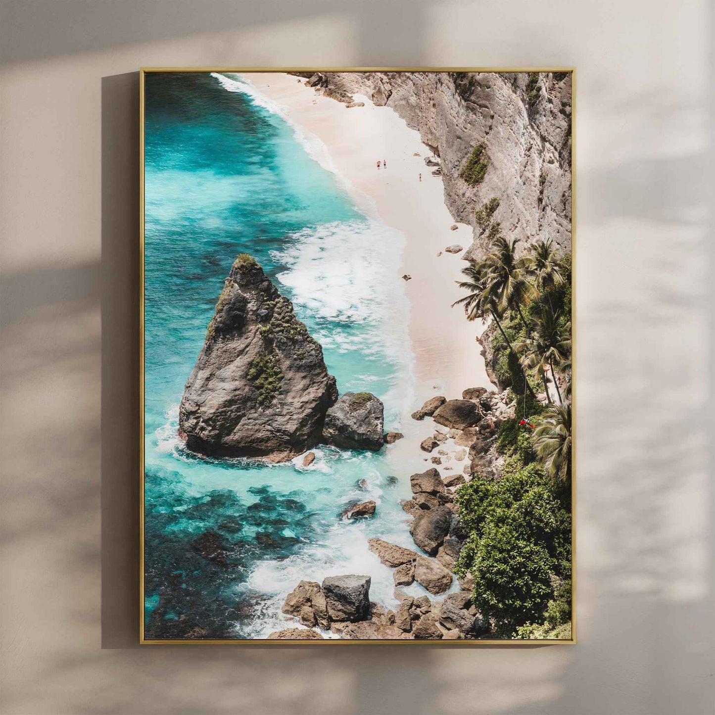Diamond Beach Nusa Penida aerial wall art print with turquoise water and rock stack in gold floating frame mounted on beige wall with natural shadows