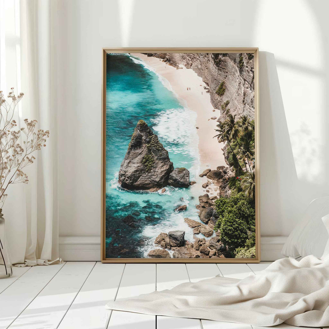 Diamond Beach Nusa Penida large framed wall art print in natural wood frame leaning against white wall with dried flowers