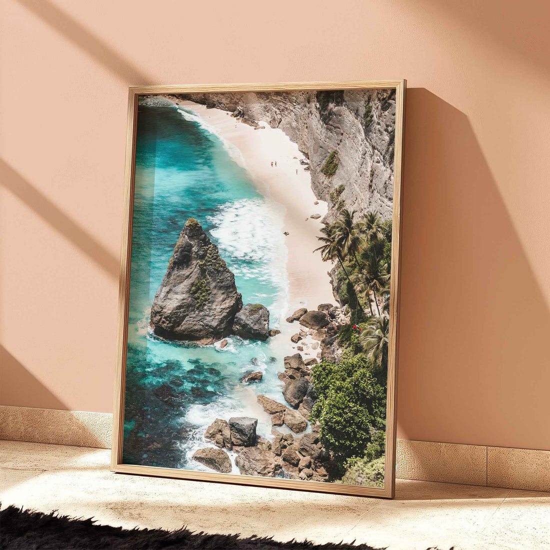 Diamond Beach Nusa Penida aerial beach print with turquoise water in natural wood frame leaning against peach terracotta wall