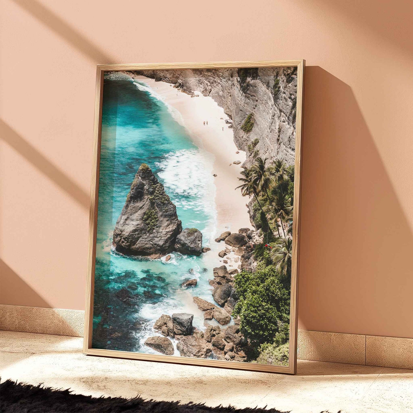 Diamond Beach Nusa Penida aerial beach print with turquoise water in natural wood frame leaning against peach terracotta wall