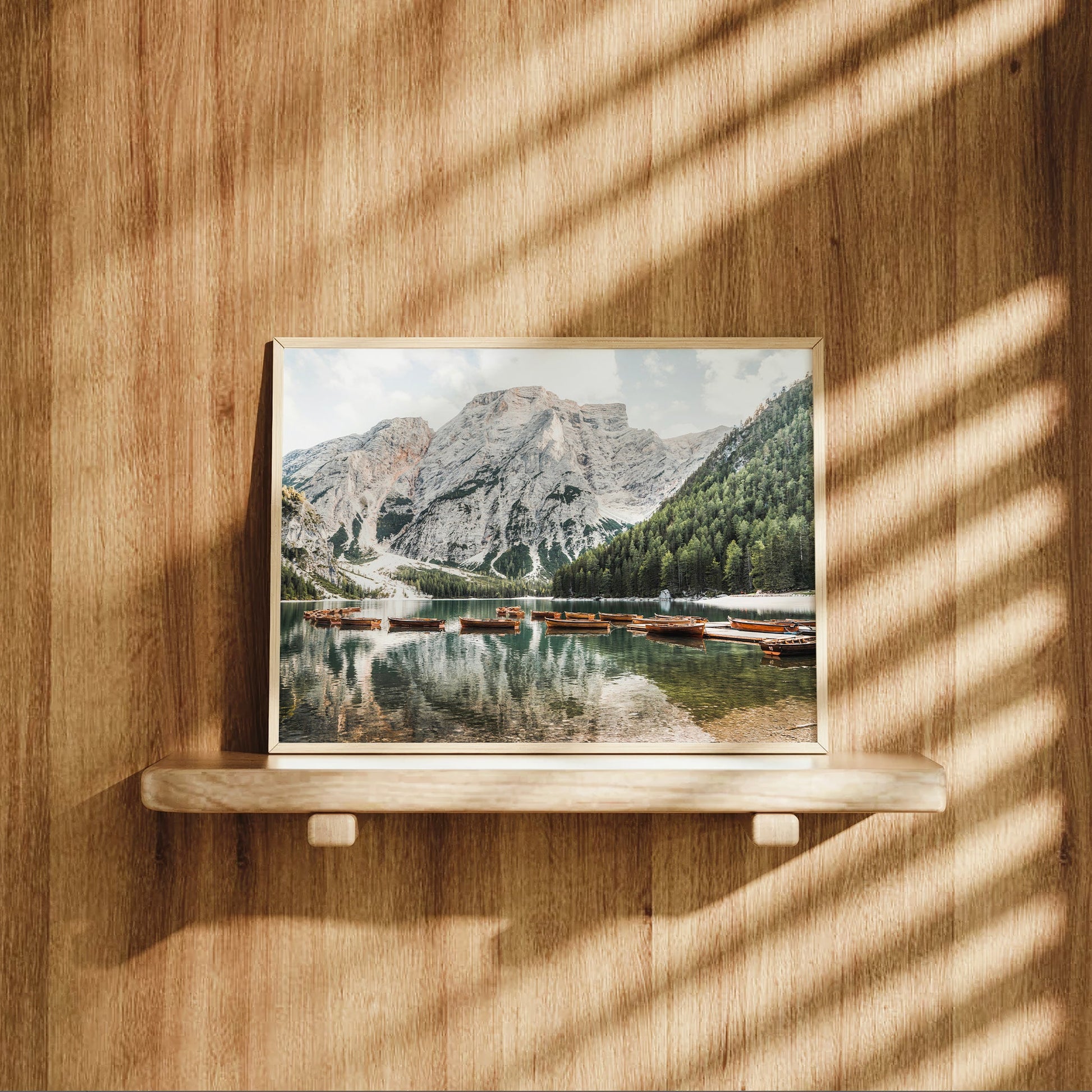 Fine art Dolomites landscape print of Lago di Braies surrounded by forest and snowy mountains with traditional wooden boats.