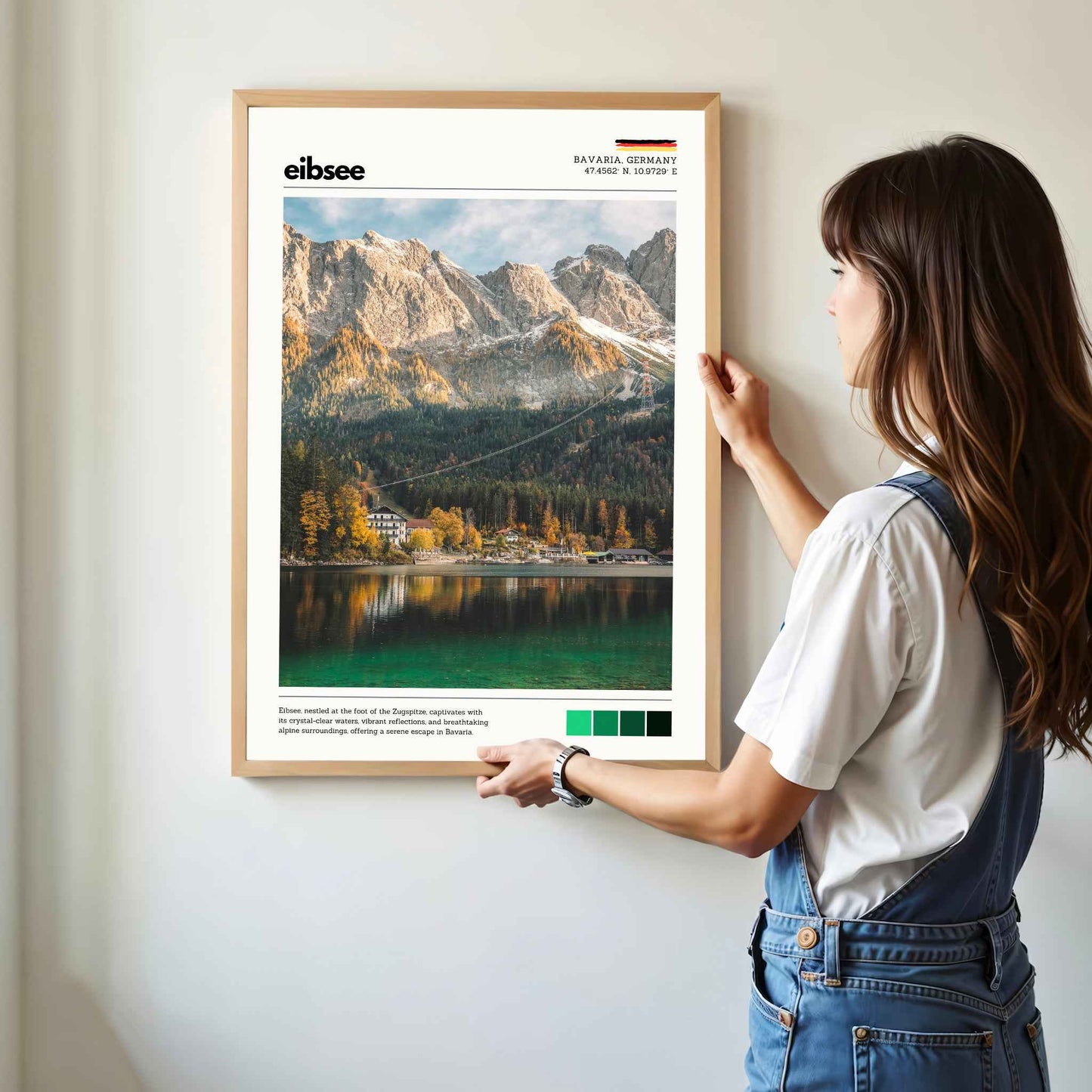 Woman hanging framed Eibsee autumn Zugspitze Bavaria Germany photography print in natural oak frame on white wall
