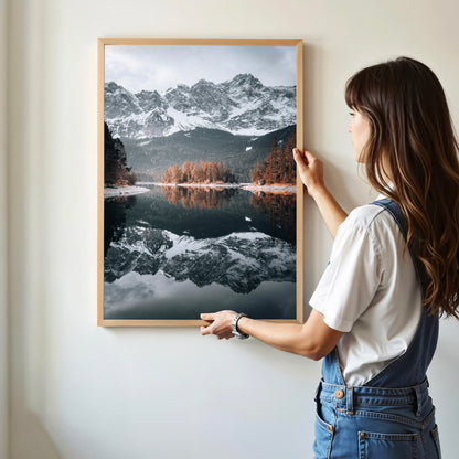 Woman hanging Eibsee fine art mountain landscape print in a natural frame