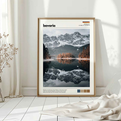 Natural wood framed Eibsee Zugspitze Bavaria Germany print leaning against white wall on white floorboards in minimal Scandinavian interior