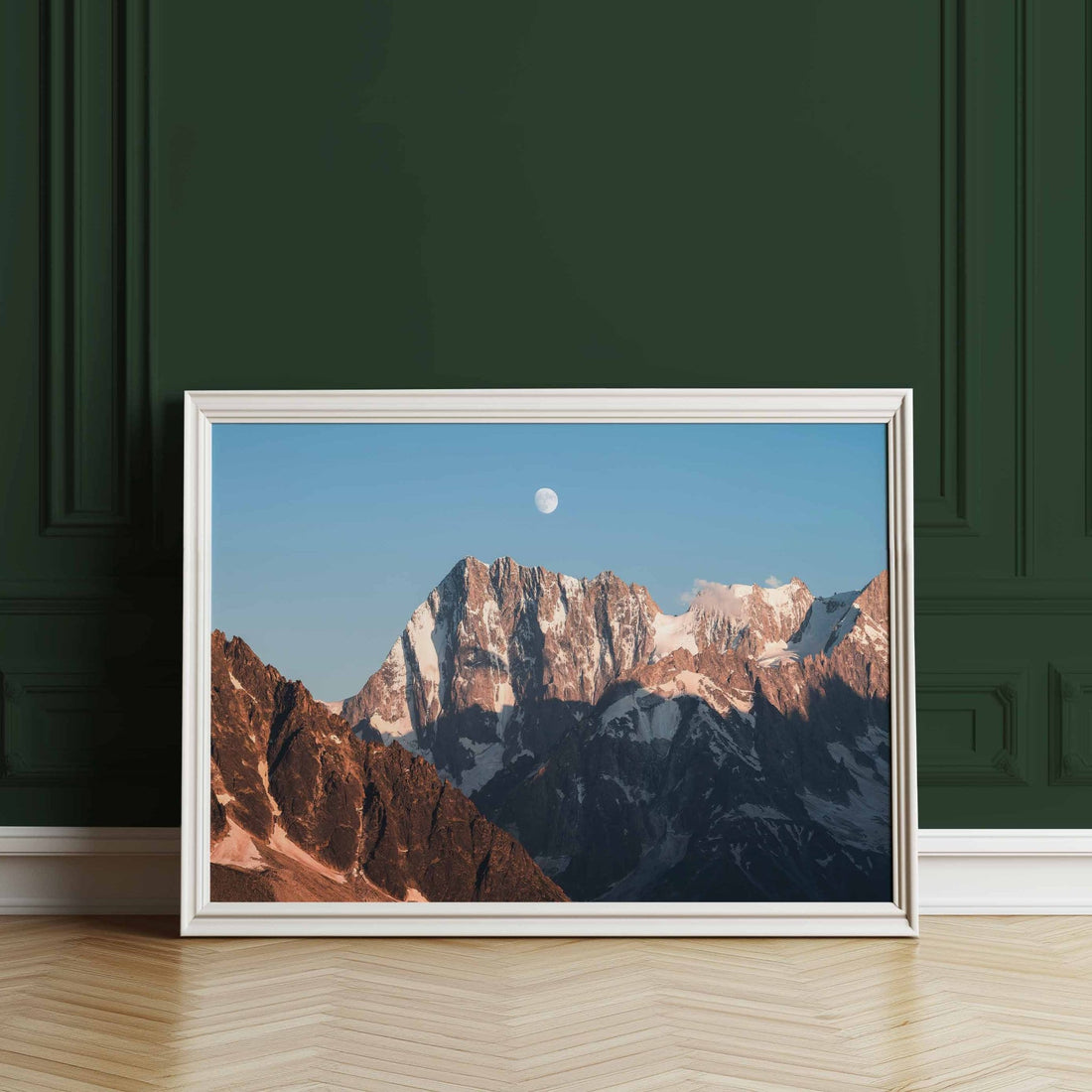 White-framed Grandes Jorasses wall art print against a dark green wall
