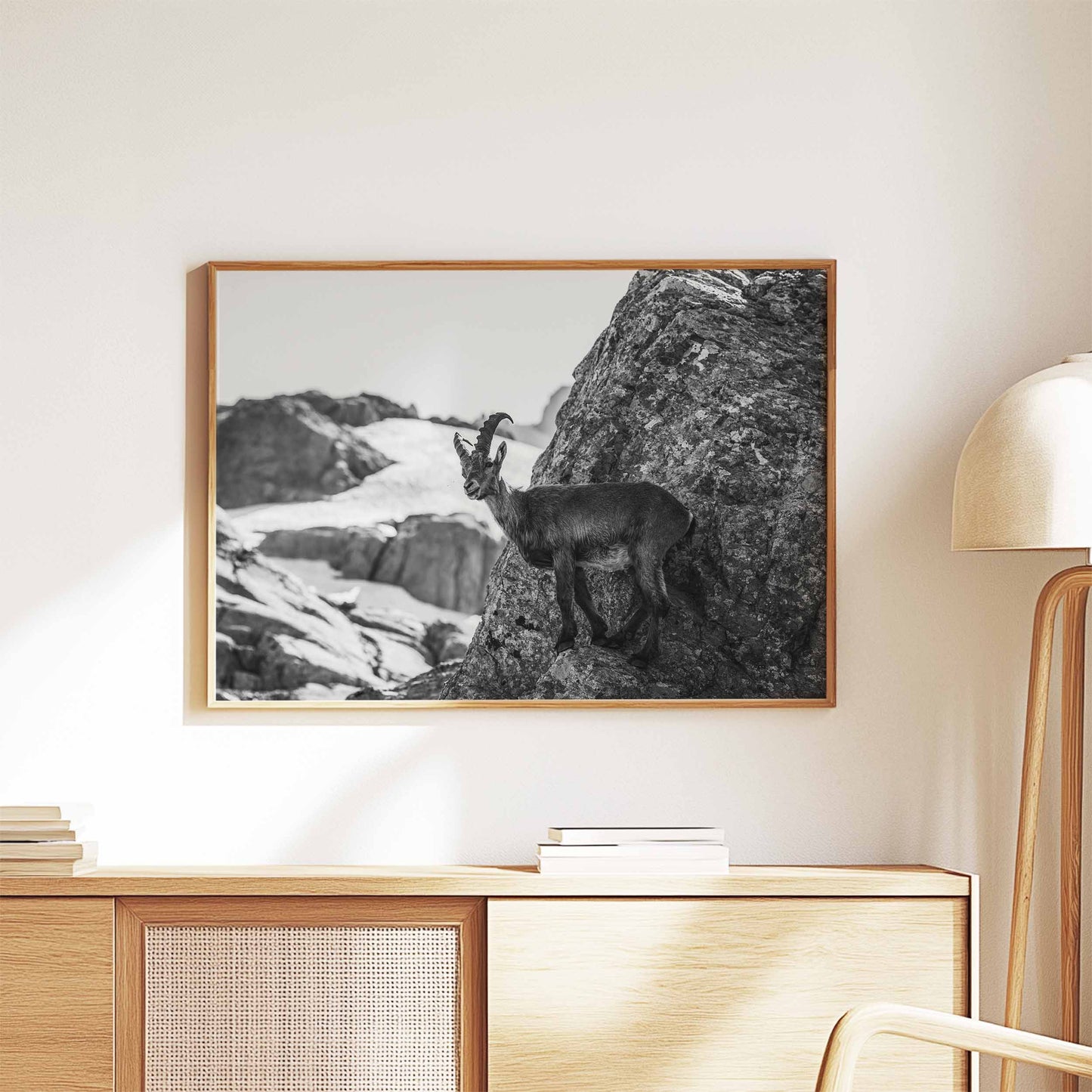 Minimalistic black and white wall art featuring an ibex perched on a rock with alpine scenery.