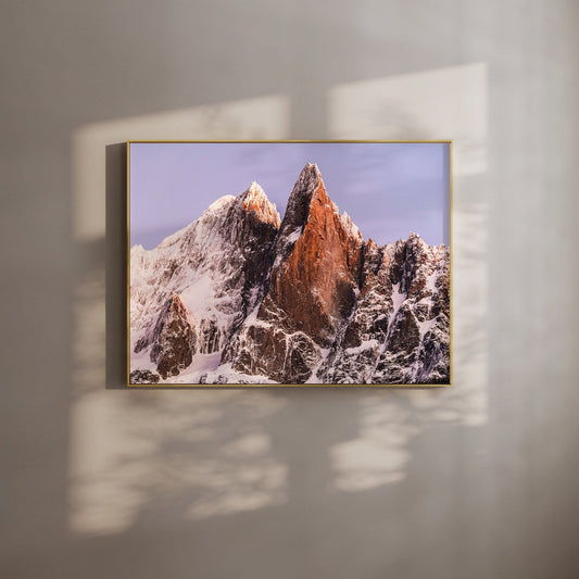 Chamonix wall art featuring Les Drus mountain peak at sunrise with golden light on the snow-covered summit.