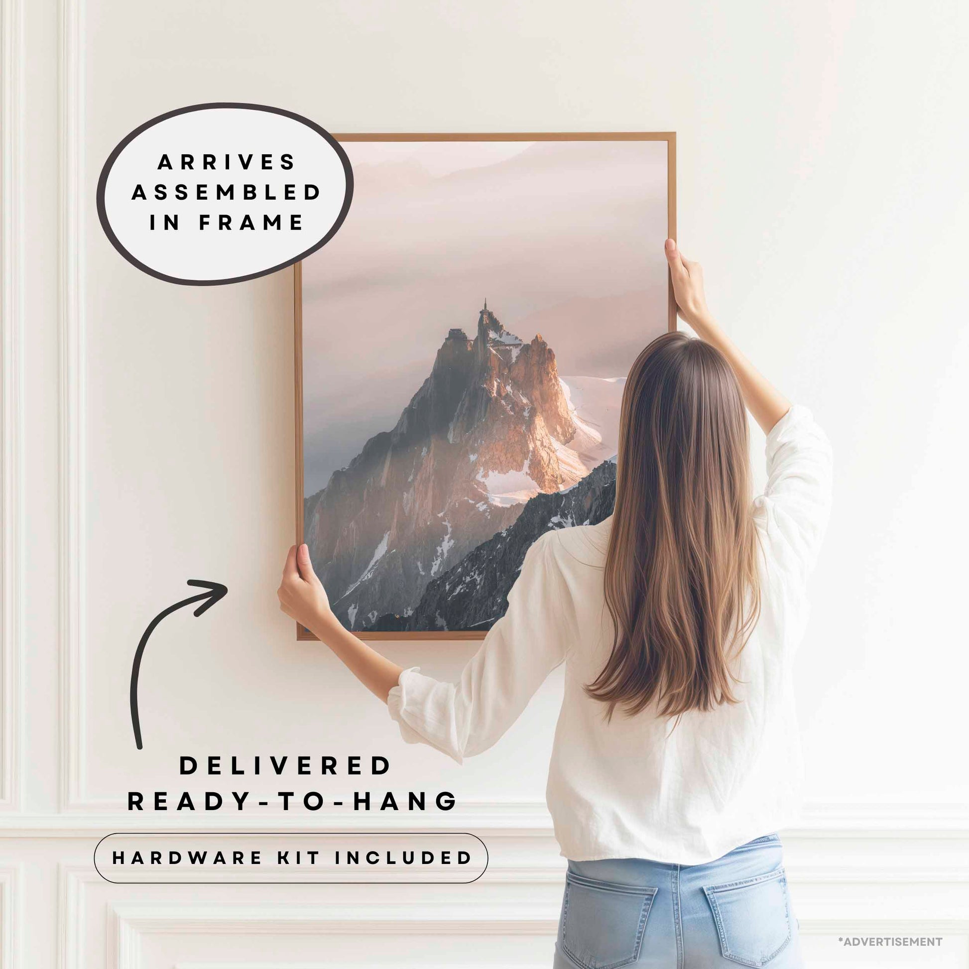 A lady hanging a framed image of the aiguille du midi