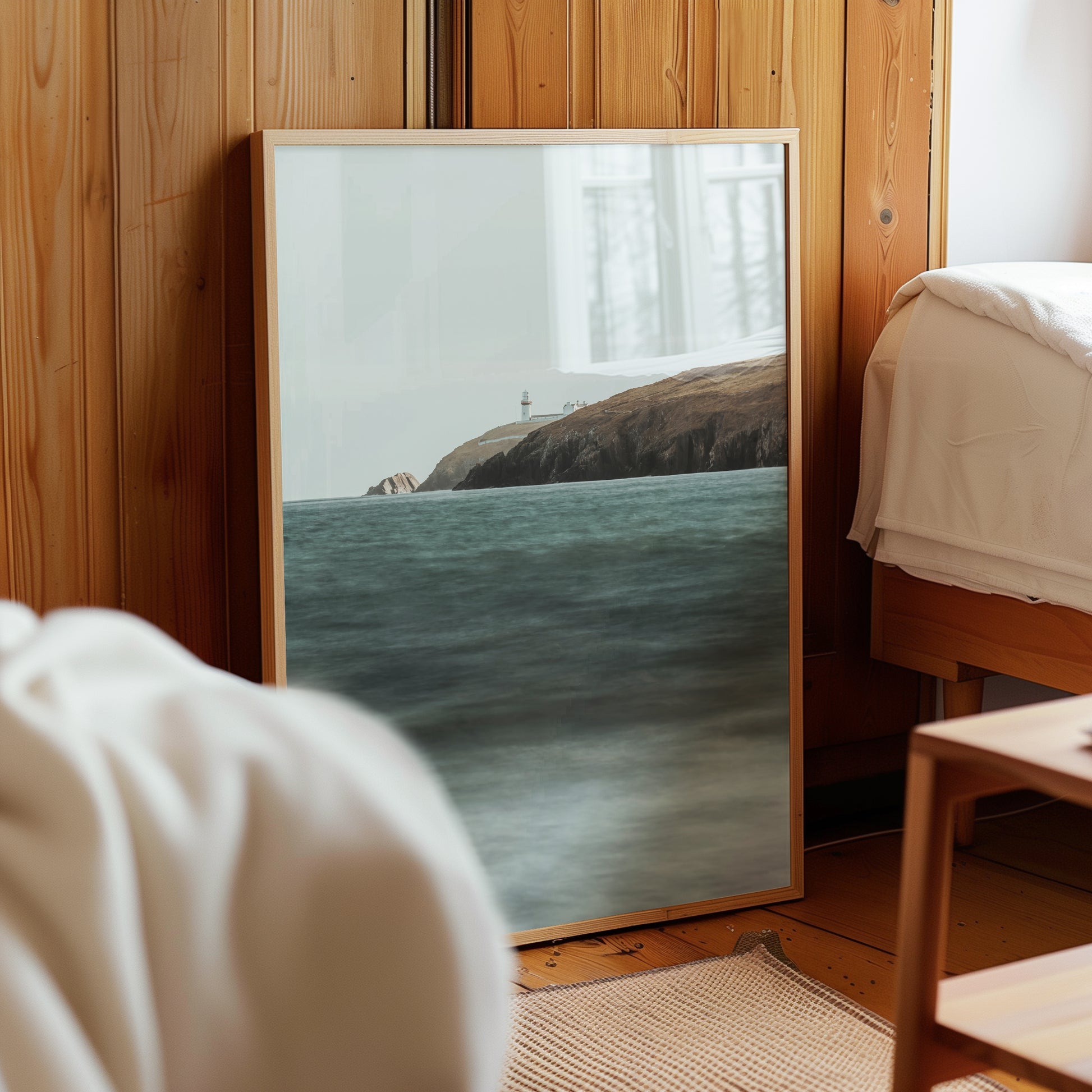 Galley Head Lighthouse print leaning against wood wall in cosy bedroom