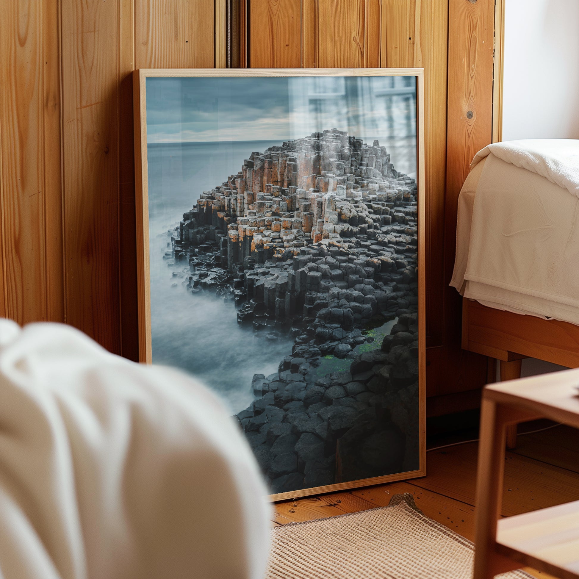 Giant's Causeway print styled against wood panelled bedroom wall
