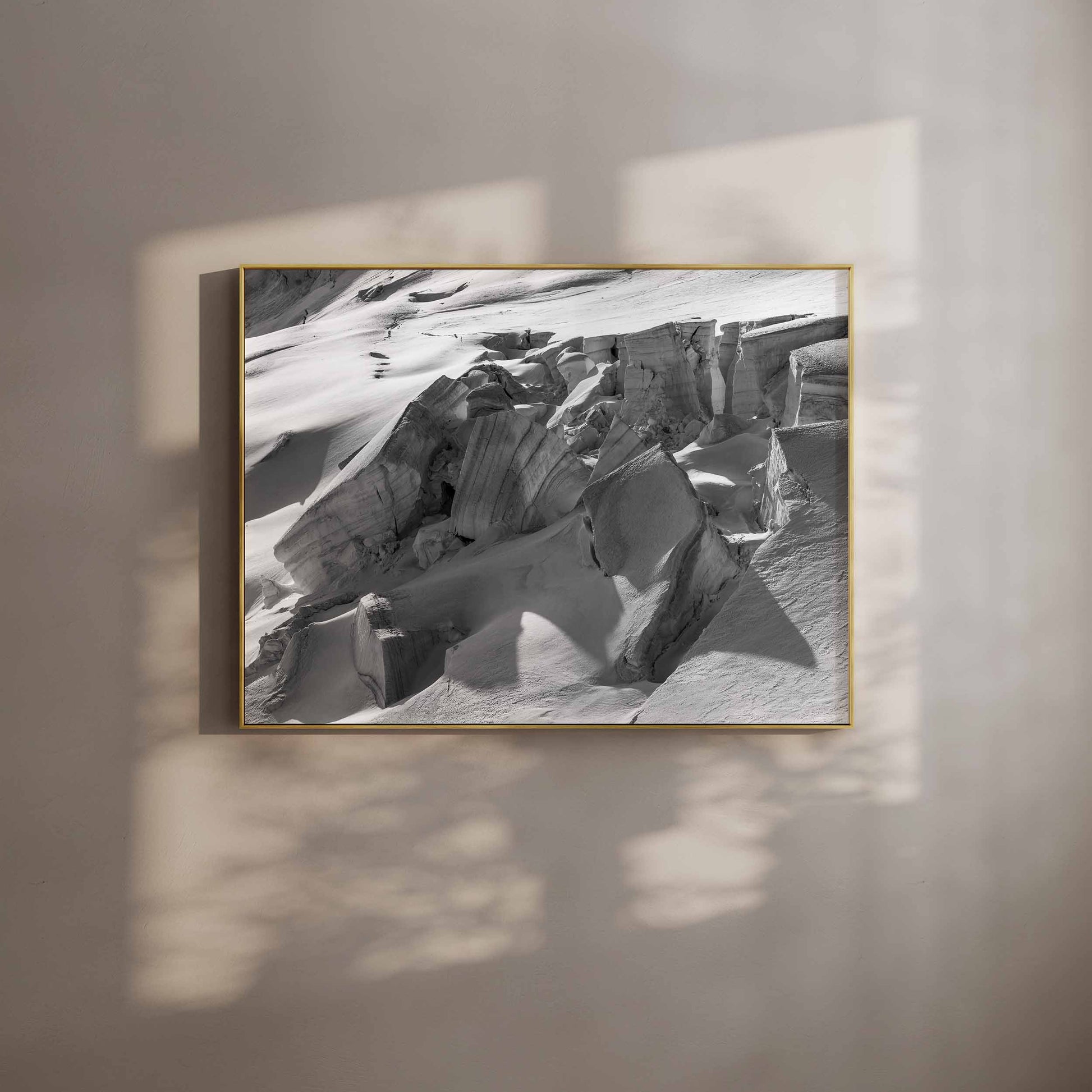 Framed print of Glacier de Taconnez in a gold frame with sunlight on the wall.