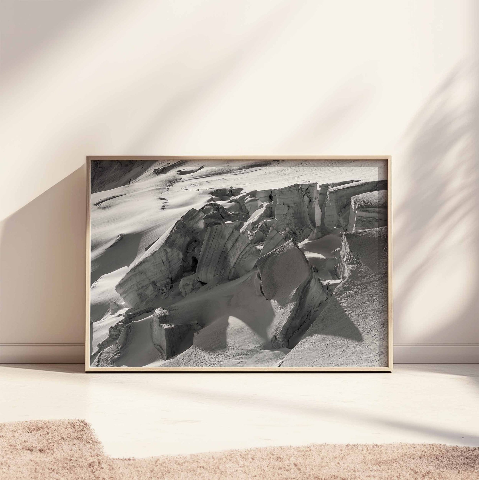 Framed print of Glacier de Taconnez in a minimalist beige frame lying on the floor with soft sunlight.