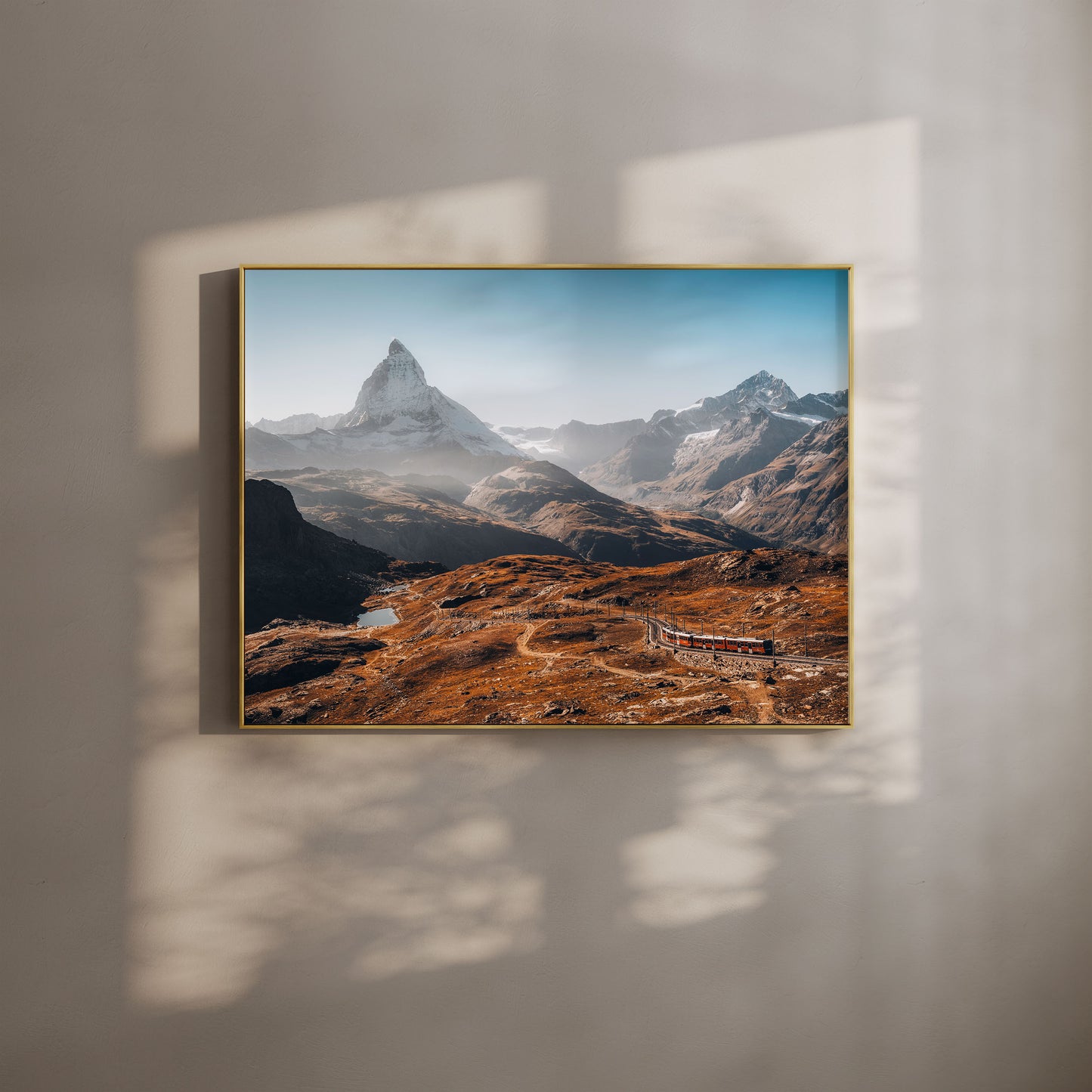 Morning view of Gornergrat and the Matterhorn with a scenic train and mountain path, captured in golden alpine light.